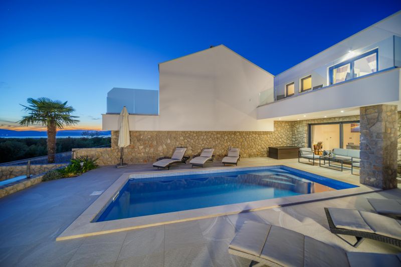 Holiday villa with pool in Croatia, pool with deck chairs and parasol and sea view