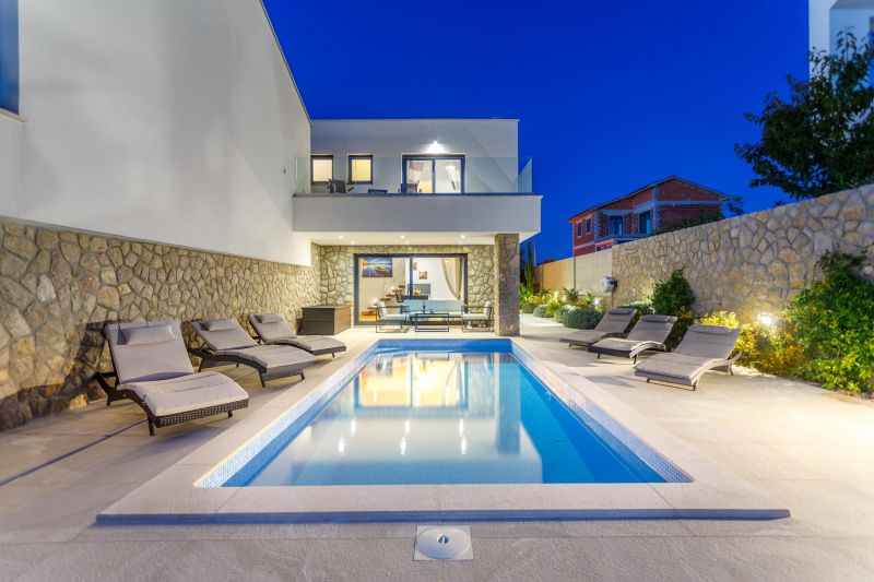 Holiday villa with pool in Croatia, pool with deck chairs