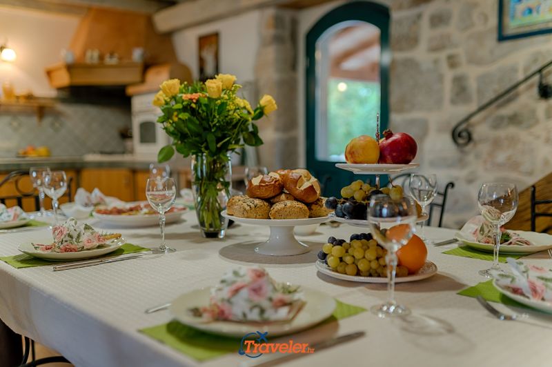 Ferienvilla mit Pool in Kroatien, Dekoration auf dem Tisch im Esszimmer, Teller und Gläser mit Obst