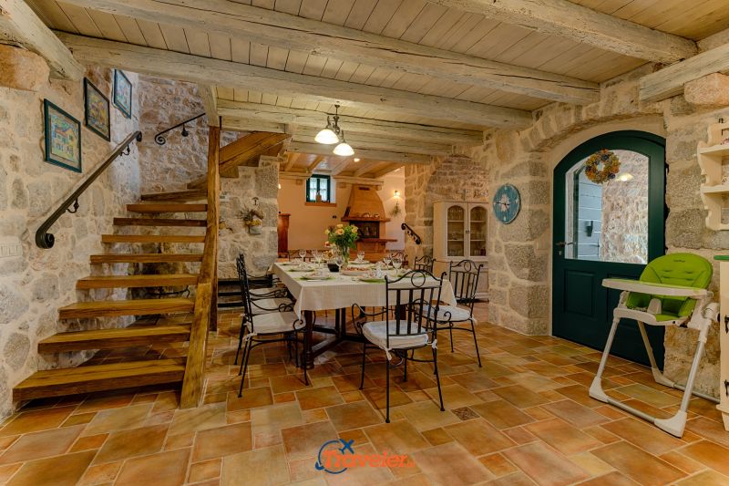Holiday villa with pool in Croatia, rustically decorated dining room with wrought iron chairs and staircase