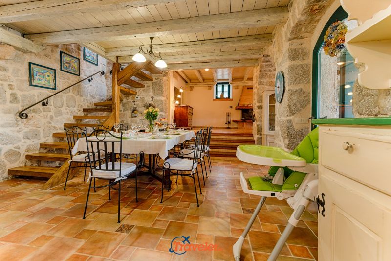Ferienvilla mit Pool in Kroatien, rustikal eingerichtetes Esszimmer mit schmiedeeisernen Stühlen und Treppe