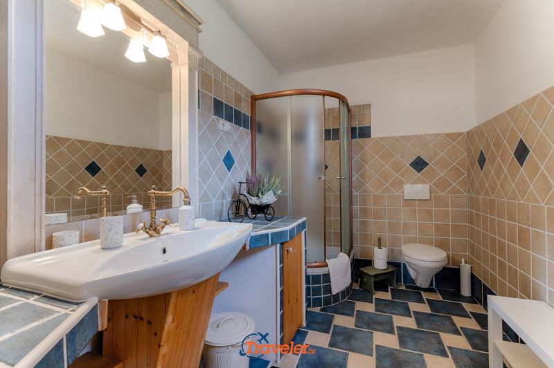 Ferienvilla mit Pool in Kroatien, Badezimmer mit Waschbecken und Dusche und blau-weißen Fliesen