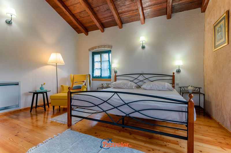 Ferienvilla mit Pool in Kroatien, Schlafzimmer mit Doppelbett und gelbem Sessel