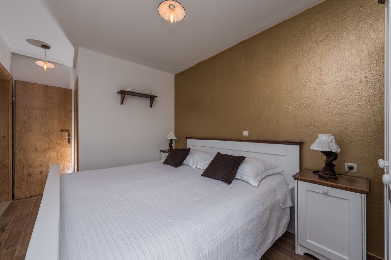 Ferienvilla mit Pool in Kroatien, Schlafzimmer mit weißem Bett und goldener Wand