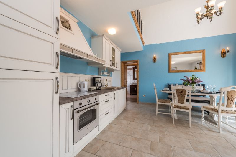 Vila za odmor s bazenom u Hrvatskoj, rustikalno uređena bijela kuhinja s plavim zidom