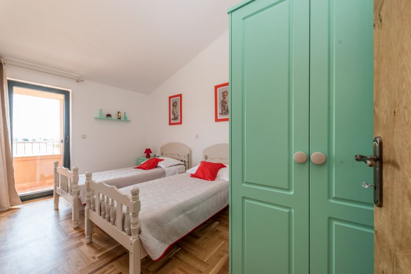 Vila za odmor s bazenom u Hrvatskoj, spavaća soba s dva kreveta za jednu osobu i zelenim ormarom
