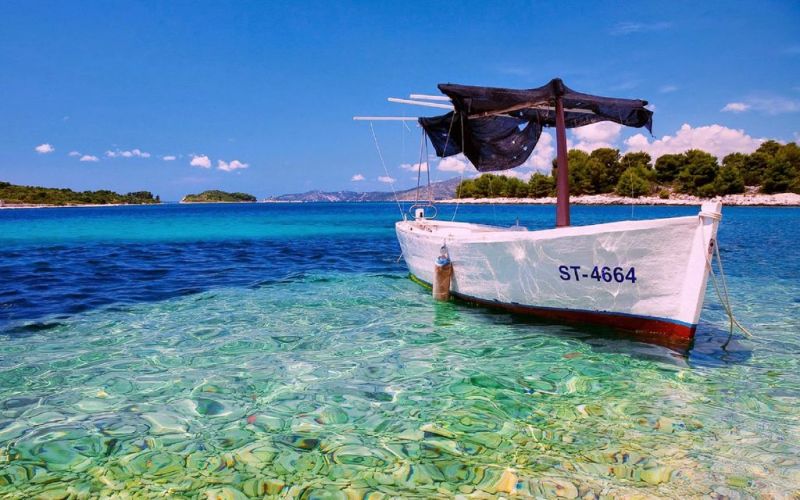 Ferienvilla mit Pool in Kroatien, türkisfarbenem Meer und weißem Boot