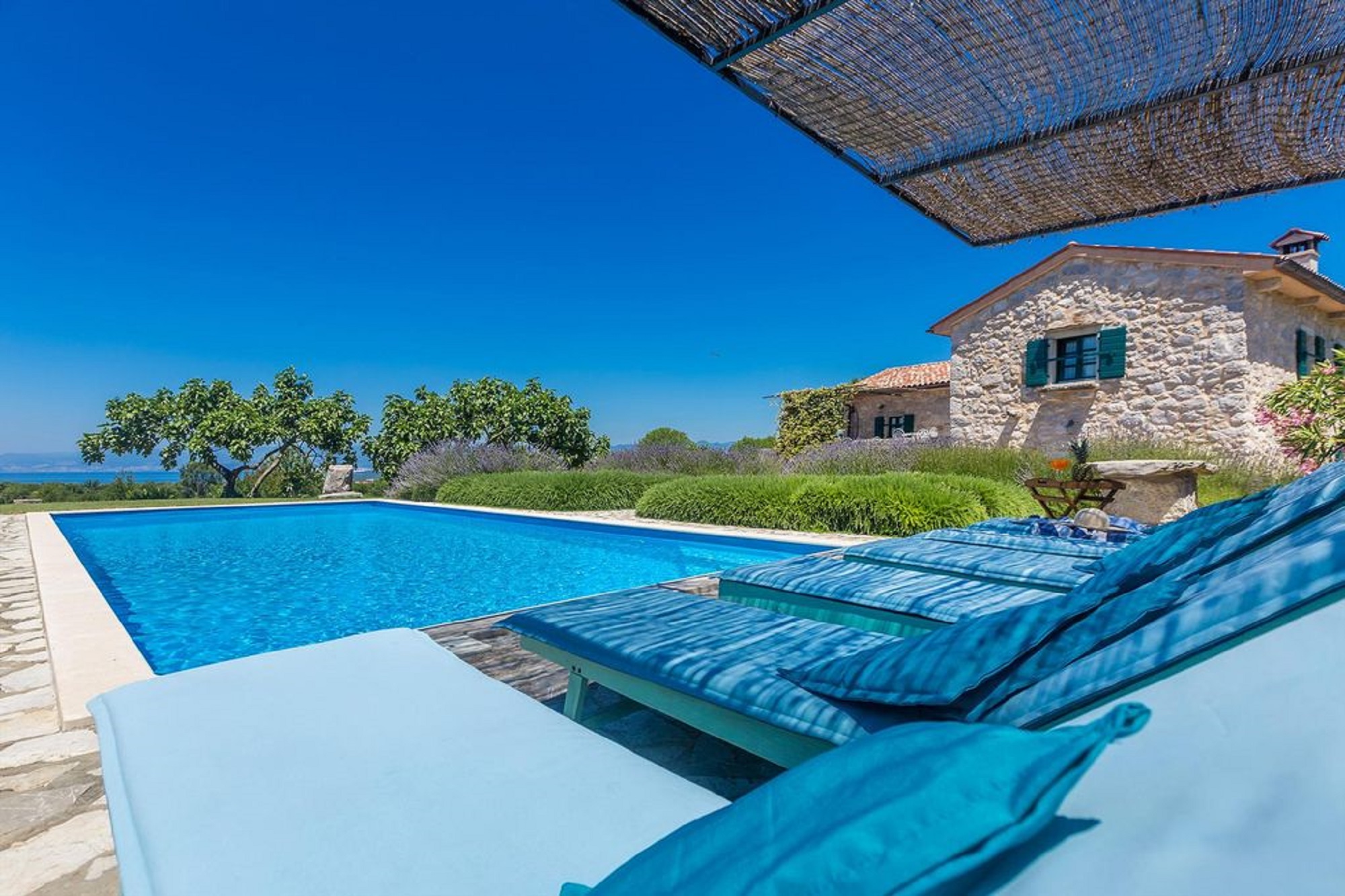 Holiday villa with pool in Croatia, pool with deck chairs