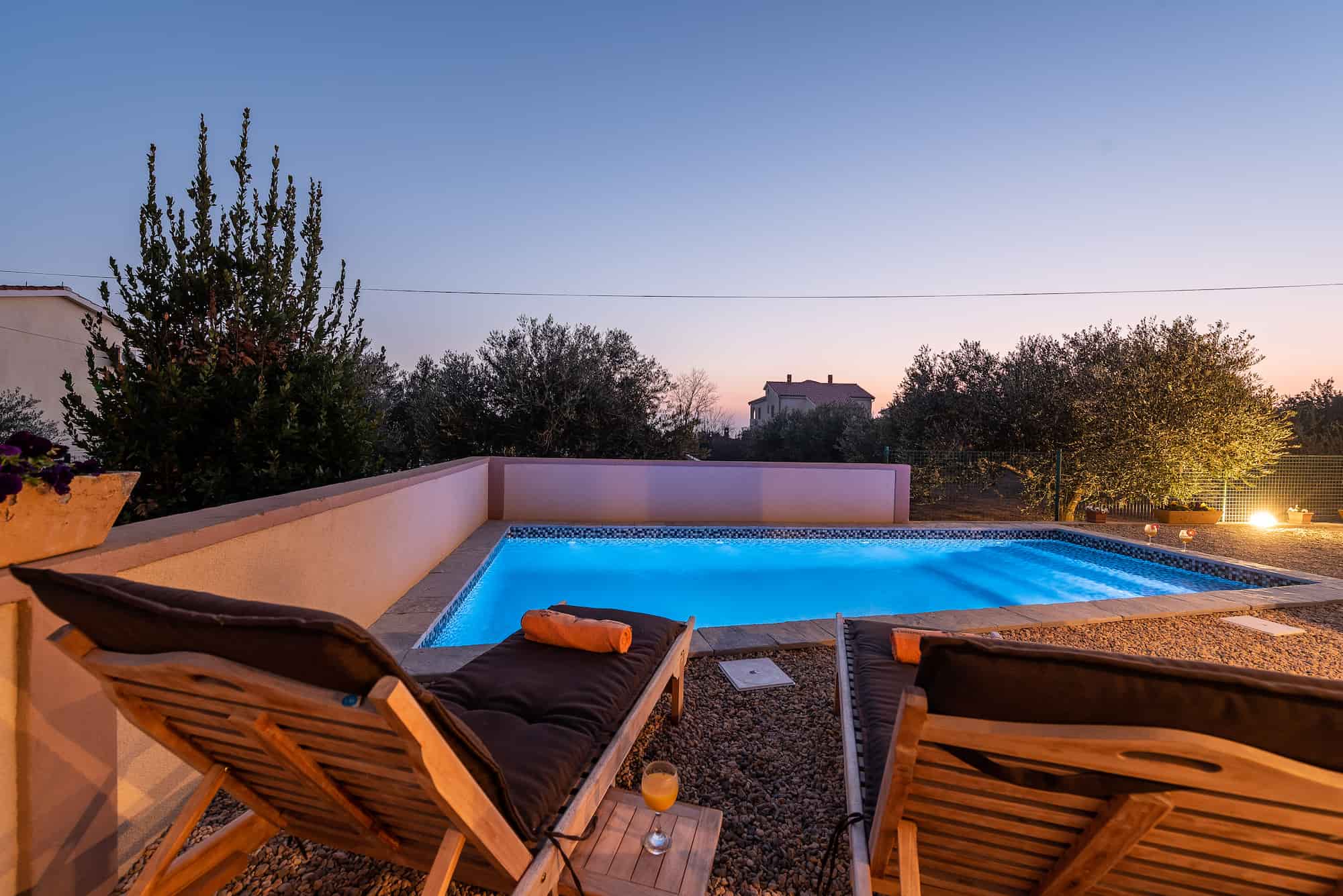 Holiday villa with pool in Croatia, night lighting of the pool and deck chairs