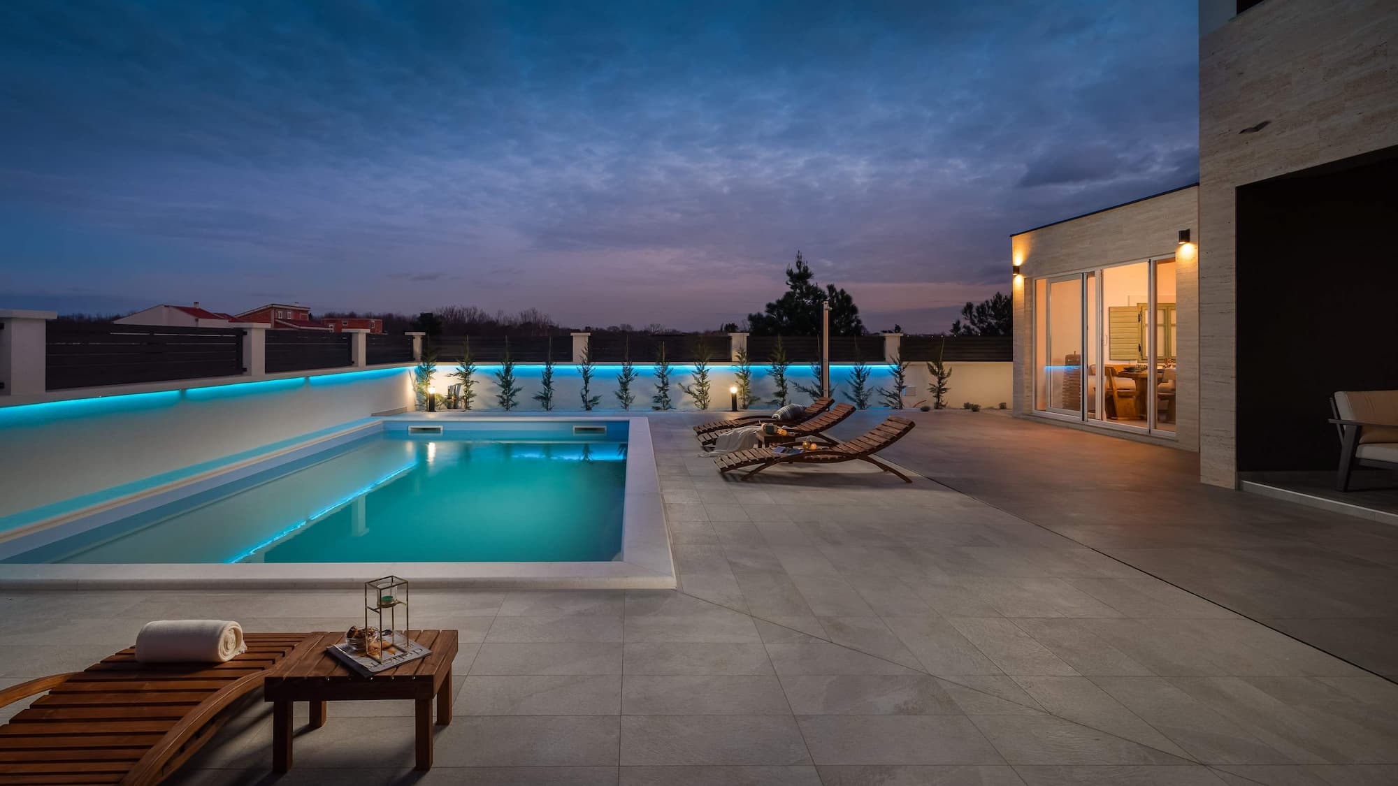 Swimming pool with sun loungers and blue night lighting