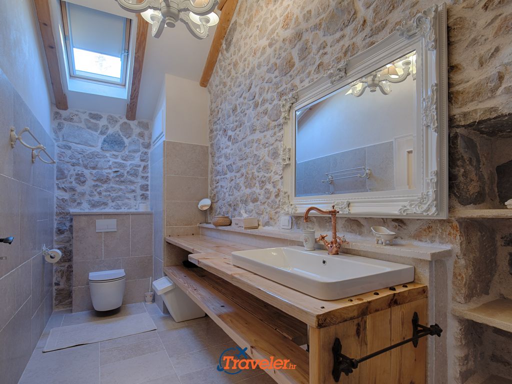 Badezimmer mit Waschbecken und Toilette im rustikalen Stil