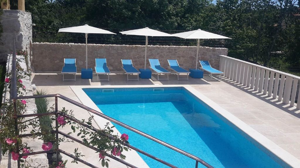 Ferienvilla mit Pool in Kroatien, Swimmingpool mit Liegestühlen und Sonnenschirmen