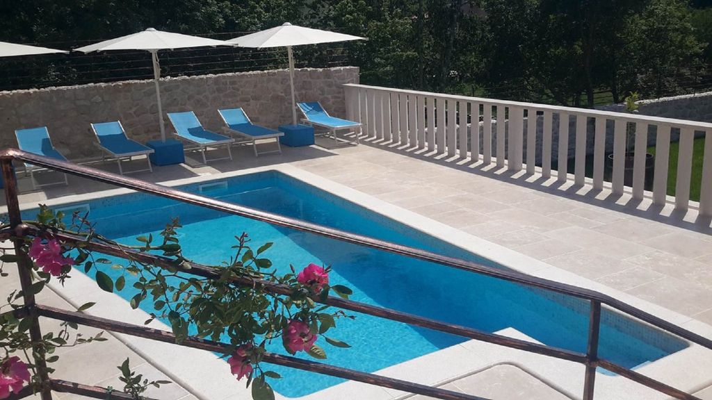 Ferienvilla mit Pool in Kroatien, Pool mit Liegestühlen und Sonnenschirmen