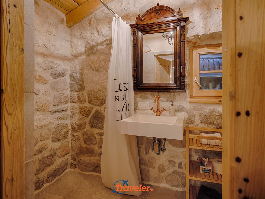 Rustikal eingerichtetes Badezimmer mit Waschbecken und Dusche