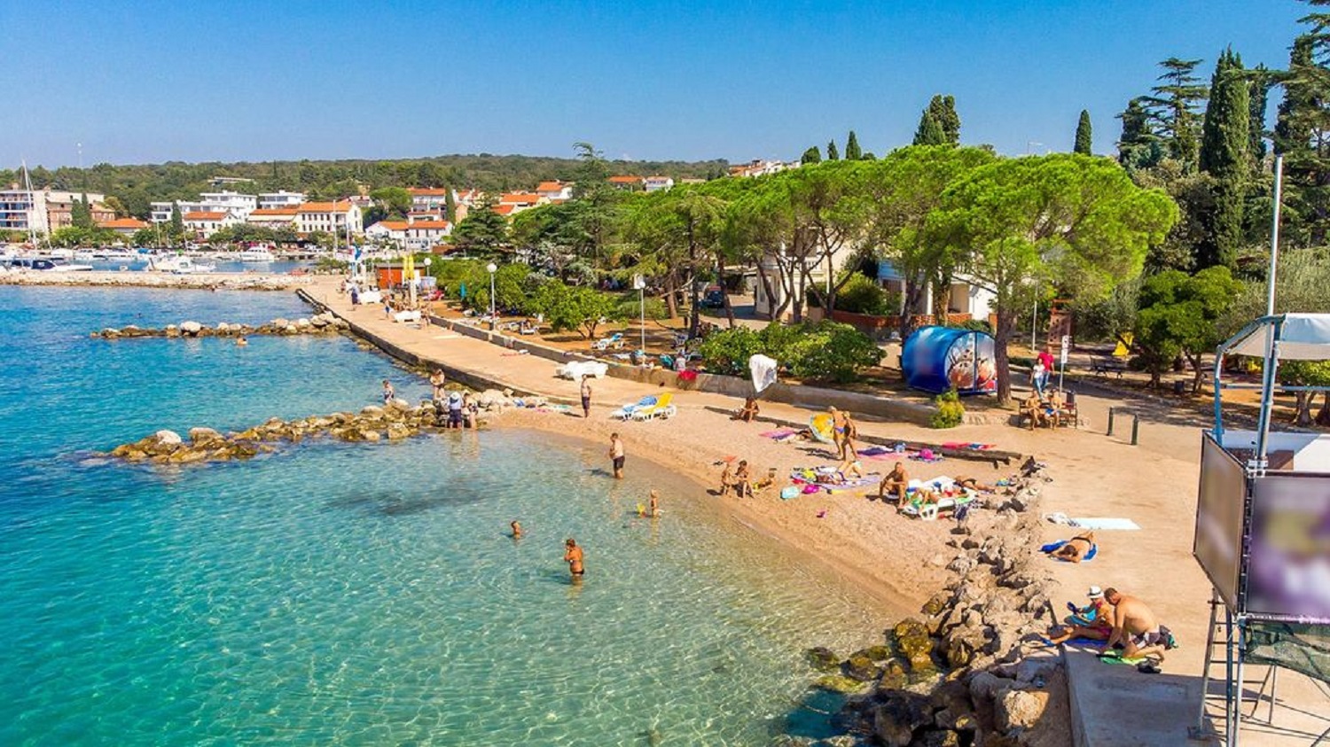 sea ​​and beach with bathers in city of Malinska
