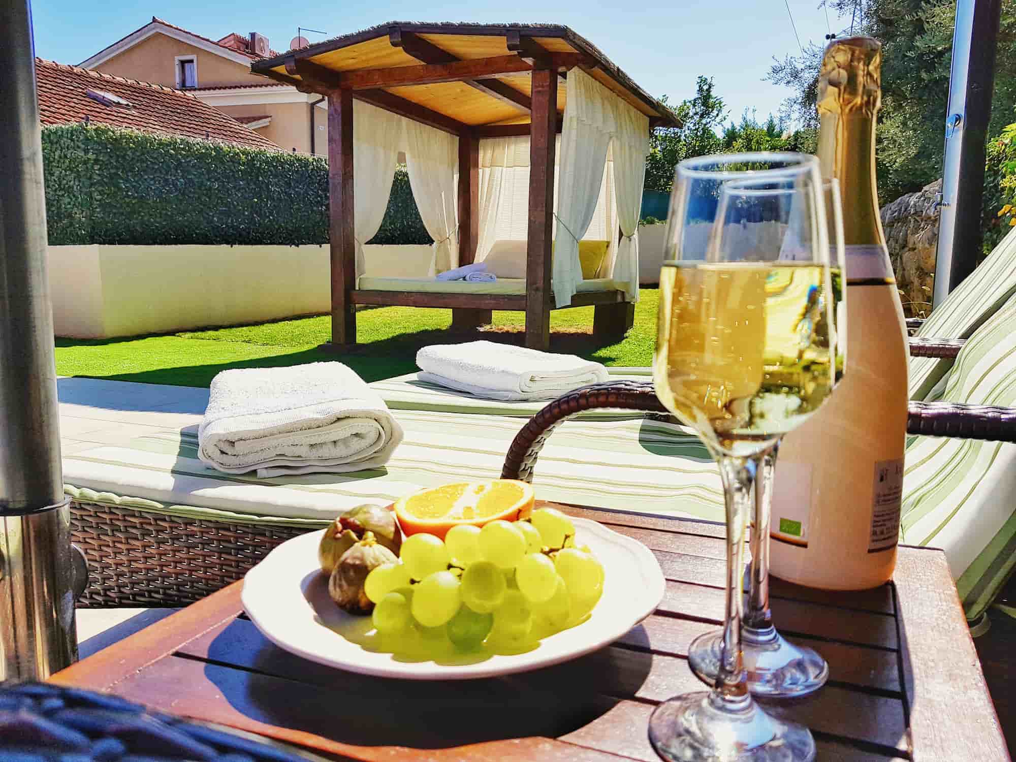Ferienvilla mit Pool in Kroatien, Teller mit Feigen, Orangen und Trauben und Champagner