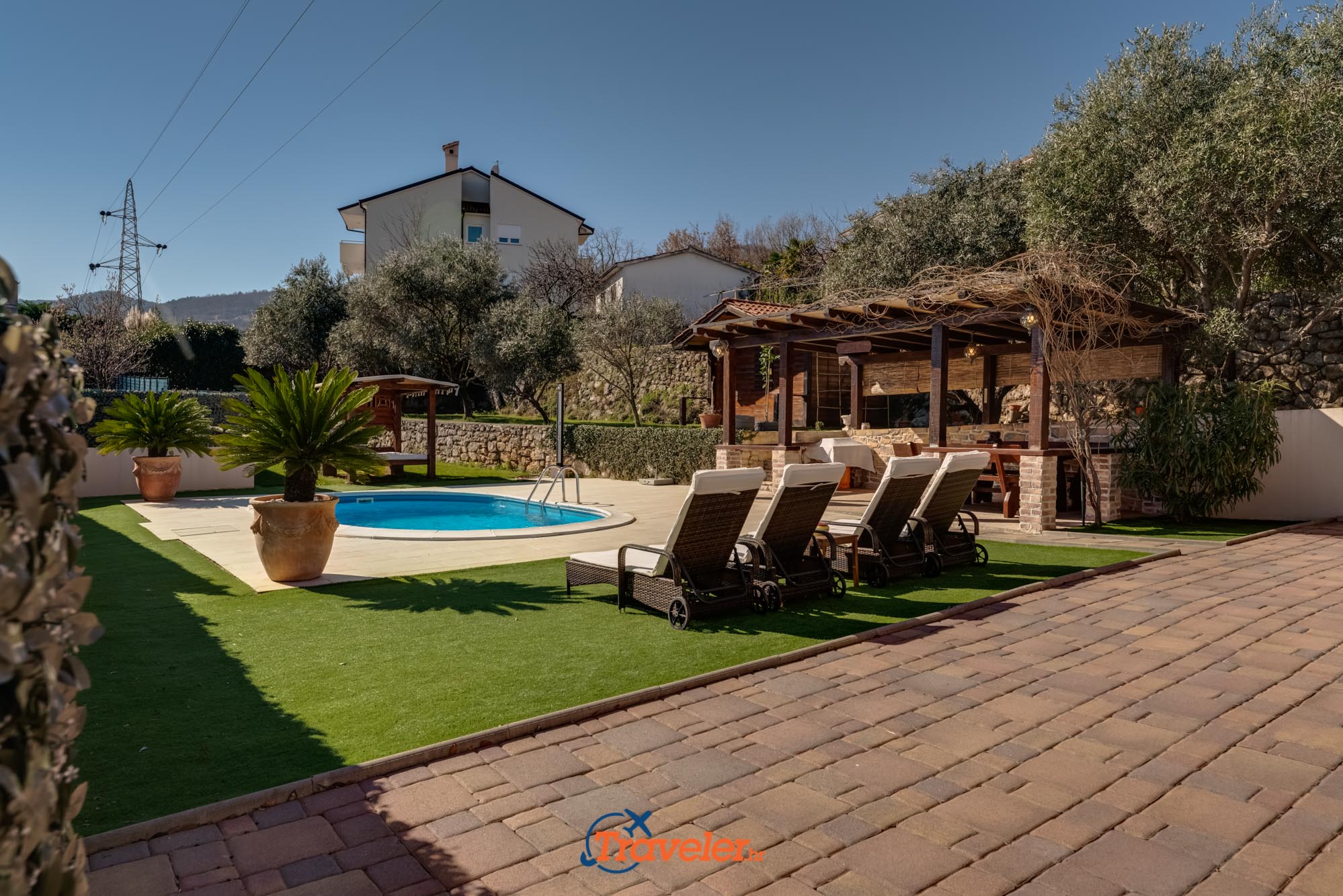 Ferienvilla mit Pool in Kroatien mit überdachter Terrasse und Liegestühlen zum Sonnenbaden auf der Wiese